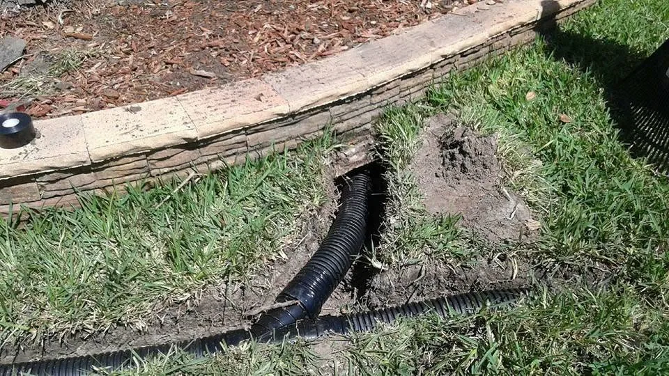 Black corrugated drain pipe trench lawn mulch bed curb, Sanford